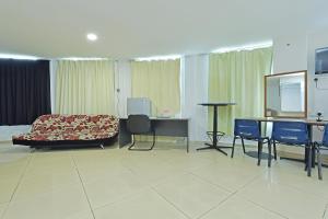 a hotel room with a bed and a table and chairs at Hotel O Sam Huat Hotel in Kampong Atap