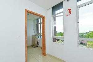 a room with a door and two windows at Hotel O Sam Huat Hotel in Kampong Atap +55 photos