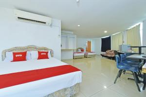 a hotel room with a bed and a table and chairs at Hotel O Sam Huat Hotel in Kampong Atap