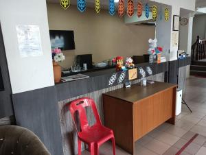 a red chair sitting at a counter in a restaurant at Hotel O Oriental Hotel in Sarikei