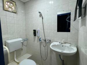 a bathroom with a shower and a toilet and a sink at Hotel O Vaigan Hotel in Bintulu