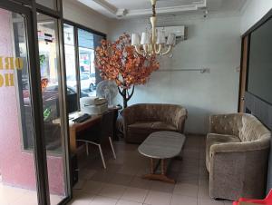 a waiting room with chairs and a table and a chandelier at Hotel O Oriental Hotel in Sarikei +25 photos