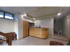 een keuken met houten kasten en een aanrecht in een kamer bij OYO 1066 Dorotello Apartelle in Manilla