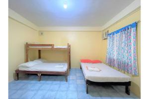 a room with two bunk beds and a window at OYO 876 Escurel Inn Boracay in Boracay