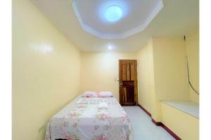 a bedroom with a bed in a room with a ceiling at OYO 876 Escurel Inn Boracay in Boracay +26 photos