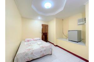 a bedroom with a bed and a tv in it at OYO 876 Escurel Inn Boracay in Boracay