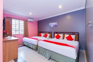 two beds in a room with pink and blue walls at Hotel O Comfort in Ipoh +43 photos