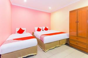 a bedroom with two beds and a cabinet at Hotel O Comfort in Ipoh