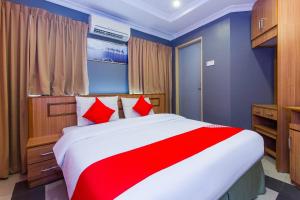 a bedroom with a large bed with red pillows at Hotel O Comfort in Ipoh
