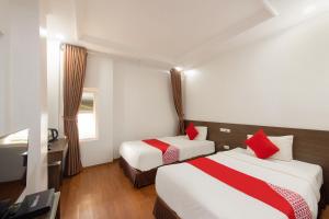 a hotel room with two beds and a desk at Super OYO Capital O 387 Bach Duong Hotel in Hanoi
