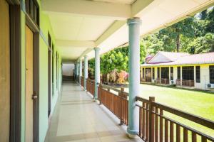 an empty corridor of a building with columns and a yard at Hotel O Terap Inn Kuala Nerang in Kuala Nerang