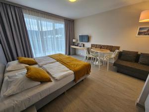 a bedroom with a bed and a table and a couch at Czarna Góra Resort, Apartament z widokiem na góry, Stubai in Biała Woda