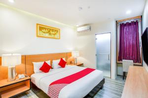a hotel room with a large bed with red pillows at OYO 489 Casa Mia Hotel Suites in General Santos