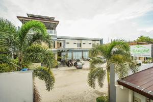 a building with palm trees in front of it at OYO 489 Casa Mia Hotel Suites in General Santos