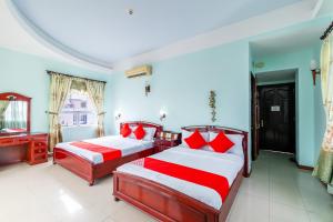 a bedroom with two beds with red and white pillows at Super OYO 266 Golden Gate in Danang