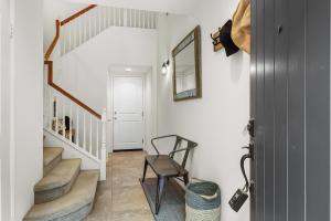 a hallway with stairs with a chair and a mirror at Spanish Walk Villa - PD condo near acrisure in Palm Desert +25 photos