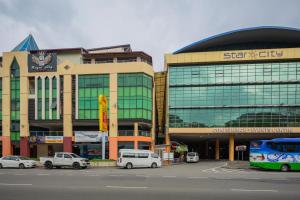 a large building with cars parked in front of it at Hotel O Storytel in Kota Kinabalu