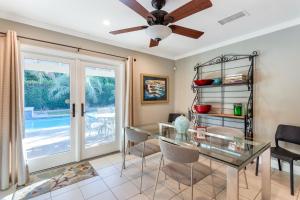 a dining room with a glass table and a ceiling fan at Vintage Paseo Getaway in Palm Desert