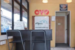 two chairs sitting at a counter in a building at Hotel O Kay Inn Kerteh in Kertih