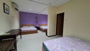 Un pat sau paturi într-o cameră la OYO 90883 Pavilion Inn Hotel