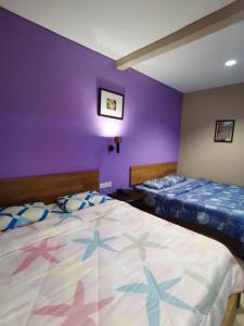 Un pat sau paturi într-o cameră la OYO 90883 Pavilion Inn Hotel