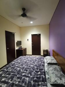 Un pat sau paturi într-o cameră la OYO 90883 Pavilion Inn Hotel