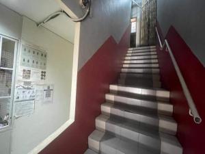 a staircase in a building with a red and white wall at Hotel O 59 in Sibu