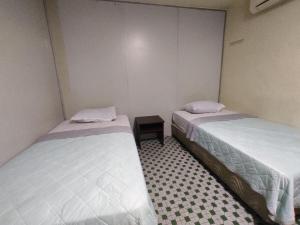 a room with two beds and a table in it at Hotel O 59 in Sibu