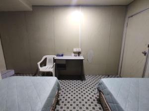 a room with two beds and a desk in it at Hotel O 59 in Sibu