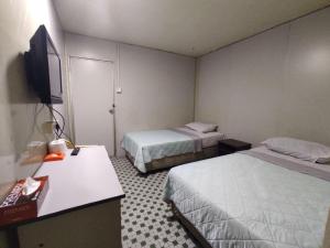 a hotel room with two beds and a flat screen tv at Hotel O 59 in Sibu