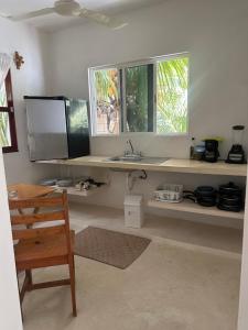a kitchen with a counter with a sink and two windows at Habitación Coco in Holbox Island