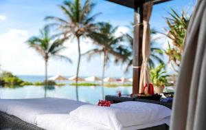 a bed in a room with a view of the ocean at InterContinental Grand Ho Tram in Ho Tram