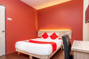 a bedroom with red walls and a bed with red pillows at OYO 778 Bmw 2 Hotel in Muar