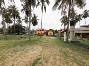 a group of houses and palm trees in a field at Hotel O Bayu Chalet in Kota Bharu