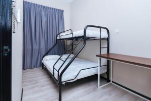 a room with two bunk beds and a desk at Hotel O Lm Residence in Miri