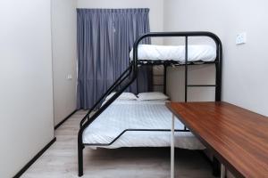 a room with two bunk beds and a wooden table at Hotel O Lm Residence in Miri +25 photos