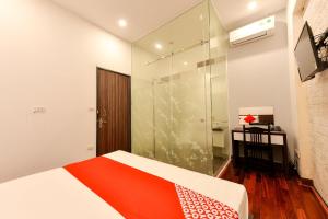 Un dormitorio con una cama y una ducha de cristal. en OYO 317 Kim Cuong Hotel 2, en Hanói
