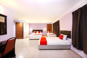 a hotel room with two beds and a desk at Super OYO 473 Comfort Hotel 2 in Klang