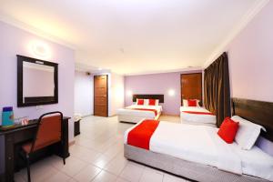 a hotel room with two beds and a desk at Super OYO 473 Comfort Hotel 2 in Klang +26 photos