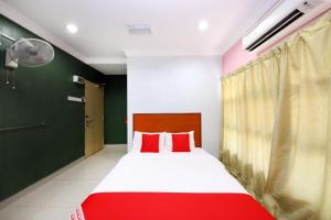 a bedroom with a red and white bed and a fan at Super OYO 720 Corridor Hotel 2 in Pekan