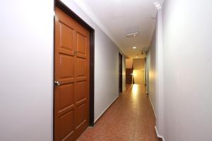 a hallway with a brown door and a tile floor at Super OYO 473 Comfort Hotel 2 in Klang +20 photos