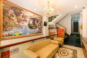 a lobby with a couch and a large painting on the wall at Super OYO 520 Friendly Homestay in Ho Chi Minh City