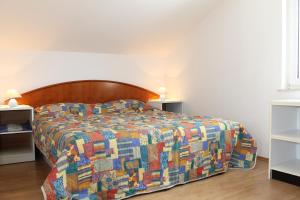 a bedroom with a bed with a colorful quilt at Apartment Mihael in Cavtat