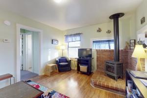 a living room with a fireplace and a stove at Greenwood Beach Cottage in Elk