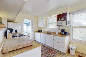 a kitchen with white cabinets and a wooden counter top at Greenwood Beach Cottage in Elk
