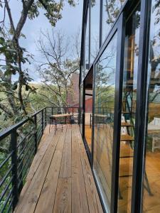 a wooden deck with glass doors and a picnic table at Cabaña Boreal, Punta del Bosque in Huasca de Ocampo