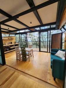 a living room with a blue couch and a table at Cabaña Boreal, Punta del Bosque in Huasca de Ocampo