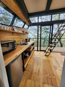 a kitchen with wooden counters and a large window at Cabaña Boreal, Punta del Bosque in Huasca de Ocampo +23 photos