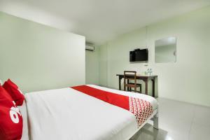 a bedroom with a white bed and a television at I Oun Inn in Nakhon Nayok