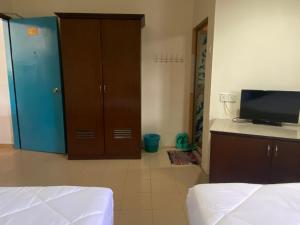 a bedroom with a bed and a cabinet and a television at Gold Hill Hotel Jerantut in Jerantut